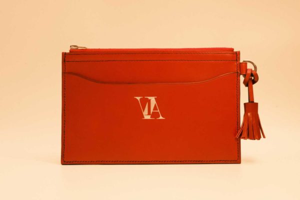 Face de la pochette Alaïa en cuir à tannage végétal cousu main avec pompon rouge bordeaux